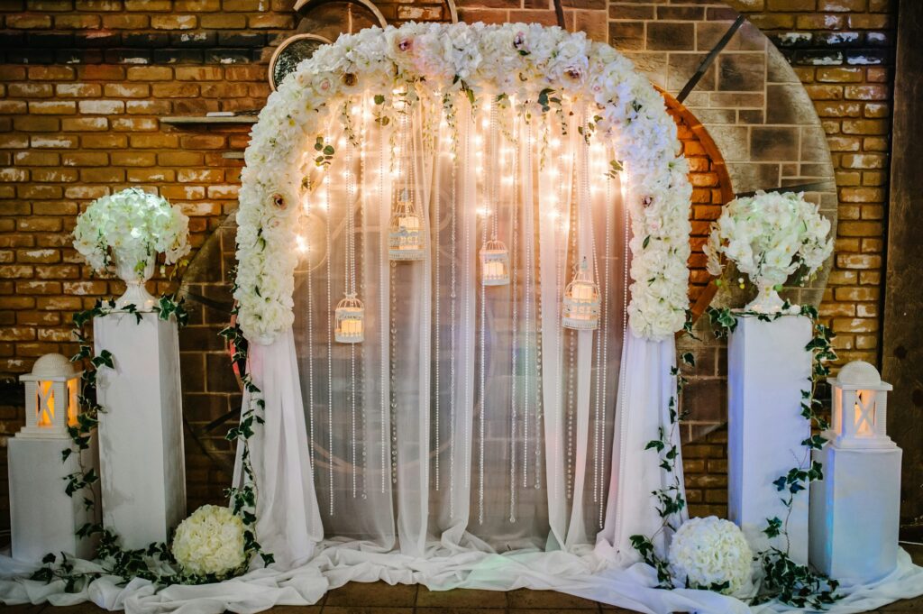 Arch for wedding area a is decorated with white flowers and greenery. Wedding ceremony with vintage